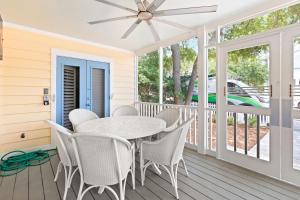 a dining room with a table and chairs on a porch at Sugar in Santa Rosa Beach