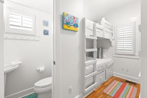 a white bathroom with a toilet and a sink at Sugar in Santa Rosa Beach +51 photos