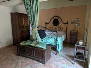 a bedroom with a bed with a canopy and a bench at Il Giovannello in Roccastrada