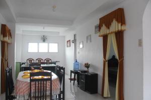 a room with a bed and a table and chairs at Rumah Mama Homestay Syariah in Bukittinggi
