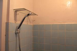 a shower head in a bathroom with blue tiles at Rumah Mama Homestay Syariah in Bukittinggi