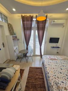 a bedroom with a bed and a window with curtains at AK mini studio u centru in Tivat