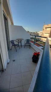 a balcony with a table and chairs on a building at Ifigeneia Infinity Suites in Néa Alikarnassós