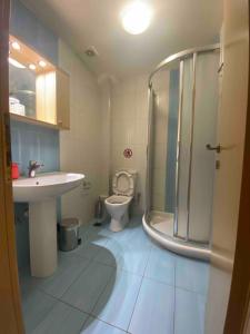 a bathroom with a toilet and a sink and a shower at Ifigeneia Infinity Suites in Néa Alikarnassós
