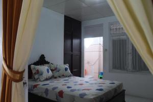 a bedroom with a bed and a window at Rumah Mama Homestay Syariah in Bukittinggi