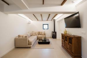 a living room with a couch and a flat screen tv at Belo Douro - Private Pool - Douro Valley - by RowdHouses in Paços de Gaiolo