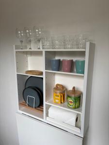 a white shelf with wine glasses and bowls at Downtown Limoges - Secure parking in Limoges