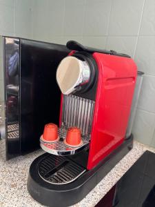 a red toaster oven with two red cups in it at Downtown Limoges - Secure parking in Limoges +7 photos