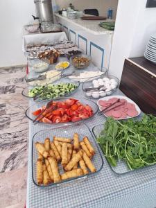 a table with plates of vegetables on a counter at Golden Beach Hotel in Didim