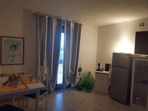 a kitchen with curtains and a table and a refrigerator at Da Rita in Villanova Monteleone