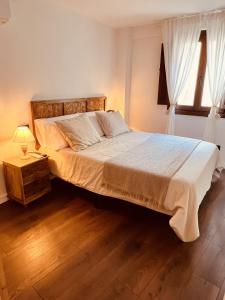 una camera da letto con un letto grande con pavimento in legno di Villa Valeria, Casa con Cueva privada del 1748 a Requena Altre 43 foto
