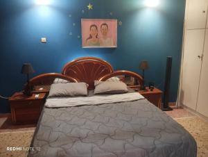 a bedroom with a bed and a blue wall at John's House in Chalkida