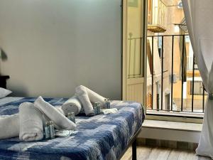 ein Schlafzimmer mit einem Bett mit Handtüchern und einem Fenster in der Unterkunft Osterio Holidays Cefalù in Cefalú