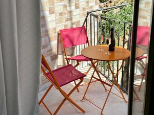 Ein Tisch und zwei Stühle mit einer Flasche Wein auf einem Balkon in der Unterkunft Osterio Holidays Cefalù in Cefalú + 4 Fotos