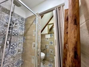 ein Badezimmer mit Toilette und Glasdusche in der Unterkunft Osterio Holidays Cefalù in Cefalú