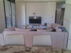 a white couch in a living room with a television at Villa GHMAT in Aghmat