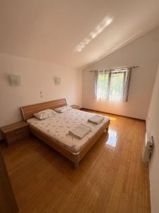 a bedroom with a bed and a wooden floor at Apartments Ćuković in Risan