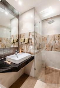 a bathroom with a sink and a glass shower at The Twilight Flora in Gurgaon