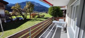 a balcony with a table and a view of a pasture at Gemütliches Appartement für Erholung und Sport in Klosters