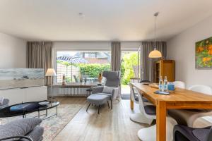 a living room with a wooden table and chairs at Haus Treibholz in Westerland