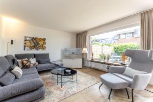 a living room with a couch and chairs and a large window at Haus Treibholz in Westerland