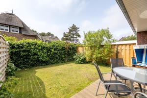 a patio with a table and chairs in a yard at Haus Treibholz in Westerland