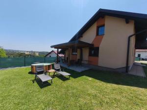a house with a table and chairs in the yard at Guesthouse and Wellness VINEA in Spodnji Ivanjci