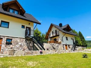 科尔别卢夫Basikowe Wzgórze的一栋房子旁边有一堵石墙，与另一栋房子相邻