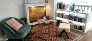 a living room with a chair and a book shelf at Les oiseaux de passage - chambre d hôtes, paisible in Gaillon +6 photos