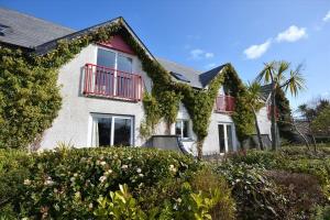 dom z bluszczem rosnącym na jego boku w obiekcie Rathlin Apartment - 2 Bedroom with Hot Tub w mieście Ballycastle