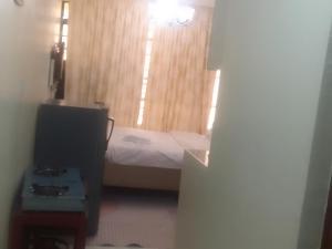 Una pequeña habitación con una cama y un televisor. en Kinoo Stays, en Rungiri 1 foto más