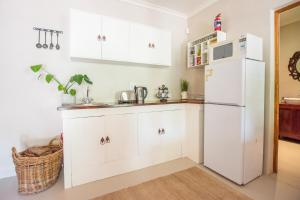 a kitchen with white cabinets and a white refrigerator at Hoogwater Cottage in Wolseley