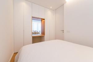 a bedroom with a white bed and a window at Estoril Palace - A chic getaway in Estoril