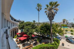 una vista dall'alto di un hotel con palme e tavoli di Estoril Palace - A chic getaway a Estoril