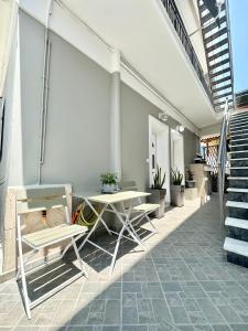 a patio with a table and chairs and stairs at Aiginetan Apartments in Aegina Town +31 photos