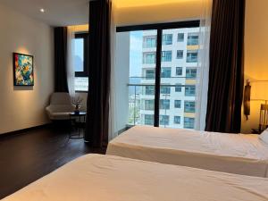 a hotel room with two beds and a large window at Lavender House- The Sapphire Resident 2 in Ha Long +6 photos