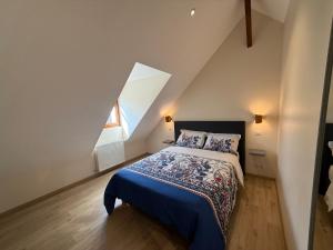 a bedroom with a bed with a blue blanket at Étage complet à la campagne in Chanzeaux