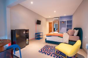 a bedroom with a bed and a chair and a table at Navee Studio Apartments Canggu in Munggu +24 photos