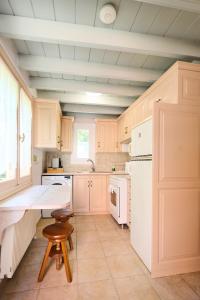 a kitchen with wooden cabinets and a white refrigerator at D BERNARDAKI Garden House in Mytilini