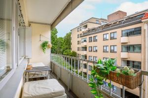 un balcon d'appartement avec un banc et des plantes dans l'établissement Design District w Free Parking Garage, Balcony, Netflix, 200m tram&bus, à Helsinki