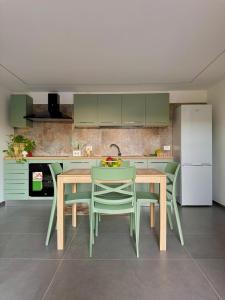 une cuisine avec des armoires vertes et une table et des chaises dans l'établissement La casetta di Lu' Loft con 1 camera da letto, à Fasano