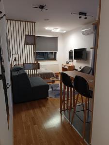 a living room with a bed and a table and chairs at Orca Apartman in Jagodina