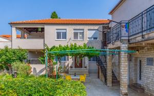a house with a patio with yellow chairs at Rooms Vilena in Medulin