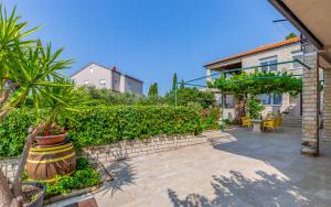 a courtyard with plants and a table and a building at Rooms Vilena in Medulin +28 photos