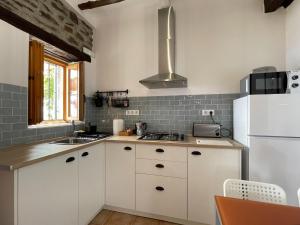 kuchnia z białymi szafkami i białą lodówką w obiekcie Casa Crisantemo with sea view and pool in Adra w mieście Las Hoyas del Barranco +37 zdjęć