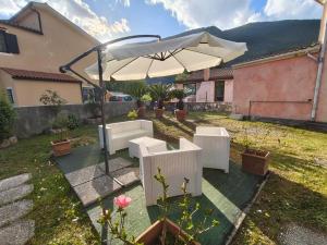 a patio with an umbrella and chairs and a table at Michi's House Casa Vacanze in Maratea +3 photos