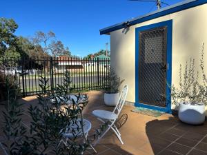 a patio with a blue door and chairs and plants at Eliza's Place - CWA Coonamble in Coonamble