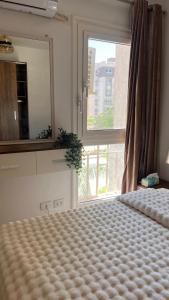 a bedroom with a bed with a large window at Modern hotel apartment in Second New Cairo in Madinaty +30 photos