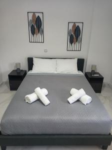 a bed with two rolled towels on top of it at Lemon Suites 2 in Mytilini