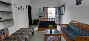 a living room with two couches and a table at SHIs Spandha Apartments Near Coimbatore Airport in Coimbatore